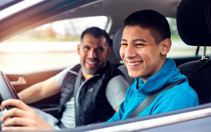A teen driver operating a vehicle with their parent in the car with them