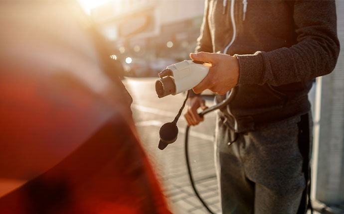 a person plugging their electric vehicle in to charge