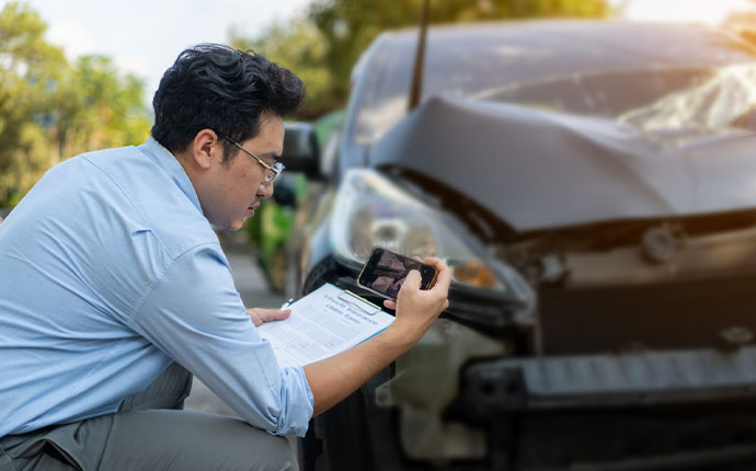 person assessing car accident damage